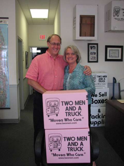 Joel and Janelle Dowley of TWO MEN AND A TRUCK, selling pink boxes for October.