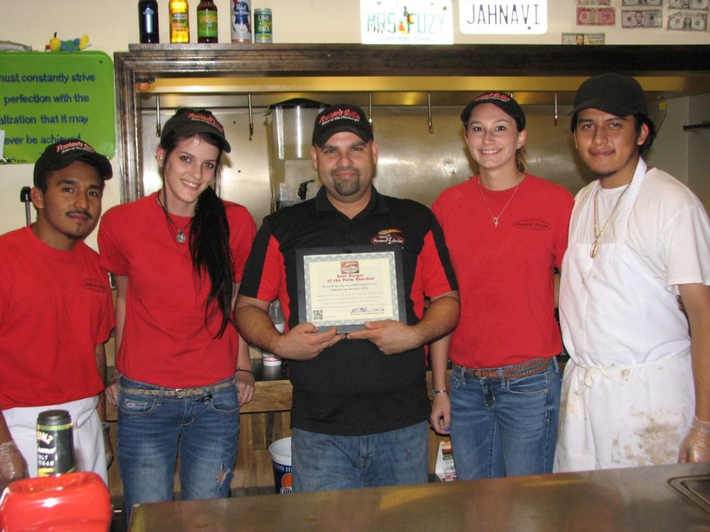 The friendly staff at Foster's Grille on Southern Blvd. in Royal Palm Beach. The Manager Axel (middle) holds their certificate for "Best Burger of the Palm Beaches," as voted on by our Around Wellington readers.